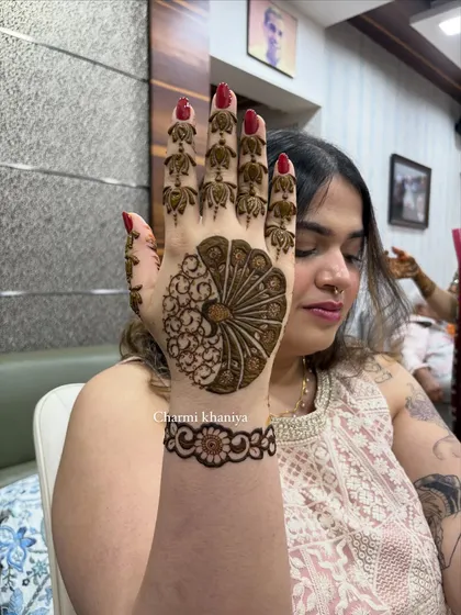 A happy client showing off her peacock mehendi. The design is bold and clear, making it a real head-turner at any party.