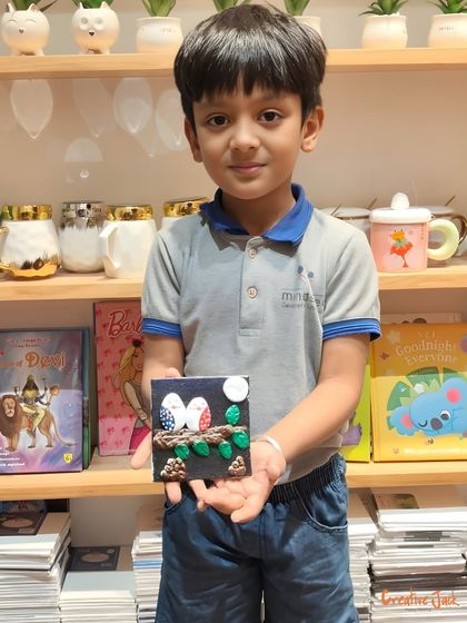 This young creator proudly presents his finished clay art, featuring two little birds on a branch. Each piece made in my workshop is a unique story.