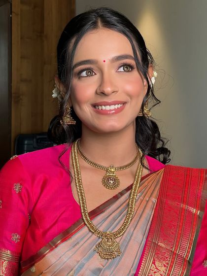 A joyful, upward glance from Soumita. Her makeup is light and radiant, perfect for a traditional South Indian wedding ceremony.