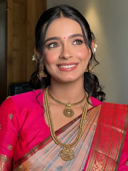 A joyful, upward glance from Soumita. Her makeup is light and radiant, perfect for a traditional South Indian wedding ceremony.