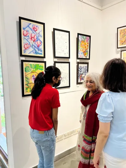 A student explaining her artwork to guests at our exhibition. These events are a huge confidence booster for our young artists.