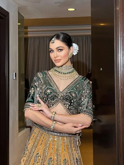 A stunning portrait of a bride in a mustard and green lehenga. I styled this with a sleek bun and floral adornment for a classic, regal look.