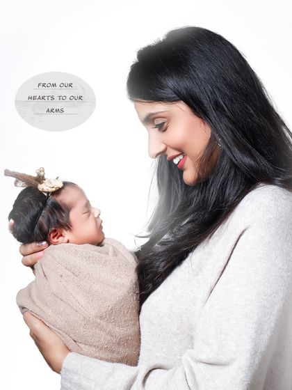 From our hearts to our arms. A mother gazes lovingly at her newborn, a simple yet profound portrait against a clean white background that highlights their connection.