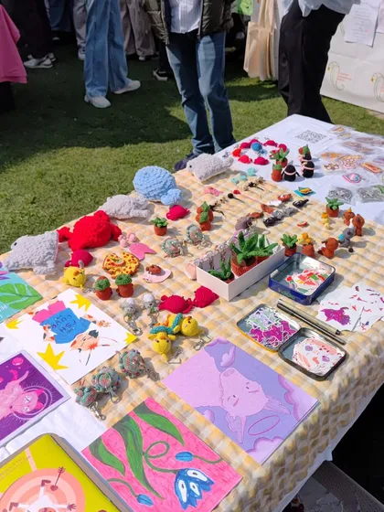 My table full of colorful creations, catching the sunlight at an outdoor market. I love how vibrant everything looks together.