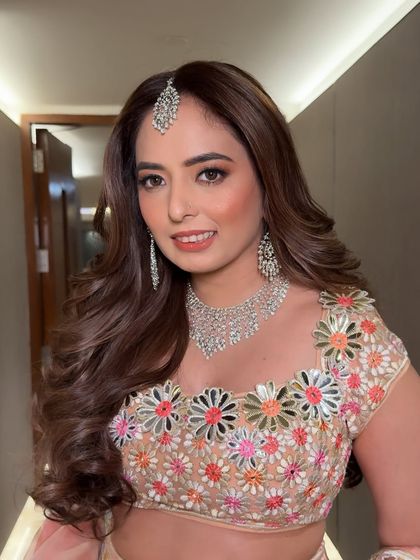 A soft and pretty sangeet look. The makeup is fresh and youthful, with a focus on glowing skin and a touch of shimmer on the eyes.