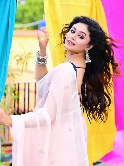A dynamic shot showing the model's back and flowing hair. The combination of the backless blouse and the colorful setting makes for a modern and eye-catching ethnic fashion photo.