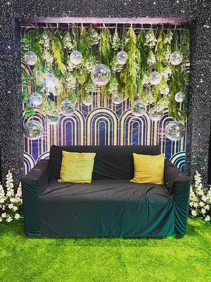 This photo booth was designed for a black and gold themed Sangeet. It features a backdrop with art deco patterns, a frame of shimmering black sequins, and hanging disco balls for that perfect party picture.