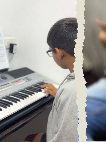 A keyboard student reads sheet music while practicing. Our curriculum, based on the Trinity College London syllabus, emphasizes music literacy.
