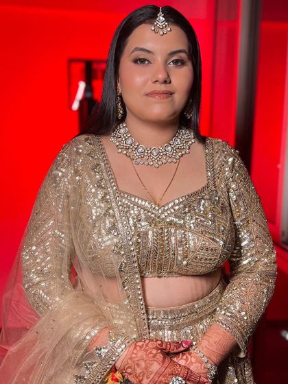 Sangeet glam doesn't always have to be dramatic. For this bride, we chose an elegant, minimal look with a focus on glowing skin, which perfectly balanced her heavily embellished golden outfit.