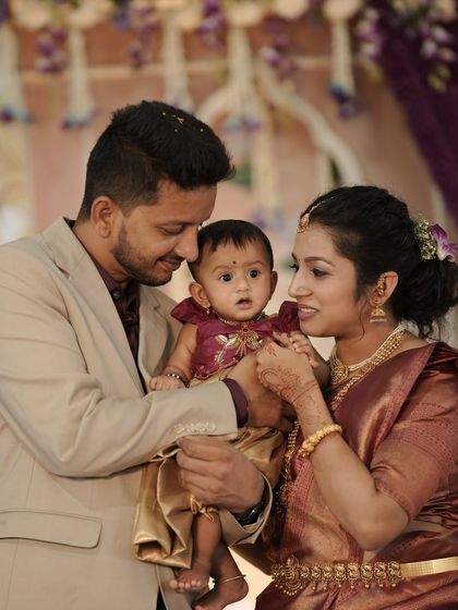A heartwarming family photo from a cradle ceremony. The soft, elegant floral backdrop provides a beautiful setting for this precious family moment.