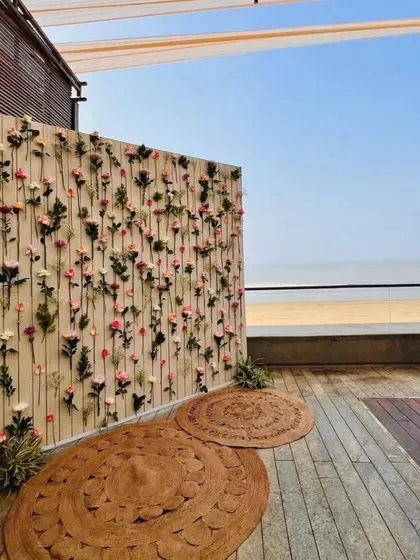 A side view of the delicate floral wall at a beachside venue, showing how it creates a stunning photo opportunity with the sea in the background.