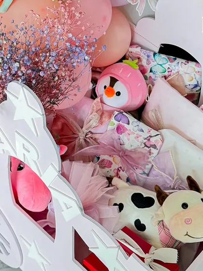 Inside the chariot, a collection of cuddly farm animal toys and other surprises await. I love to fill my hampers with a variety of textures and items to delight a child.