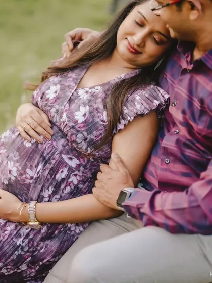 The partner joins in for a sweet, candid moment. His embrace adds a sense of warmth and shared happiness to this beautiful outdoor maternity session.