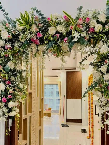 Even an apartment doorway can be transformed into a grand entrance. This lush floral arch, made with white and pink roses, baby's breath, and fresh eucalyptus, brings the beauty of a wedding venue right to your home.