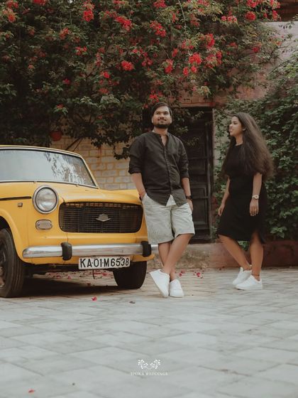 A cool, vintage-style shot of a couple posing with a classic yellow car.