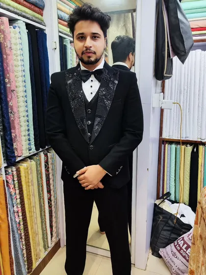 A full view of the client in his black tuxedo, featuring patterned, textured lapels that offer a modern twist on a classic garment.