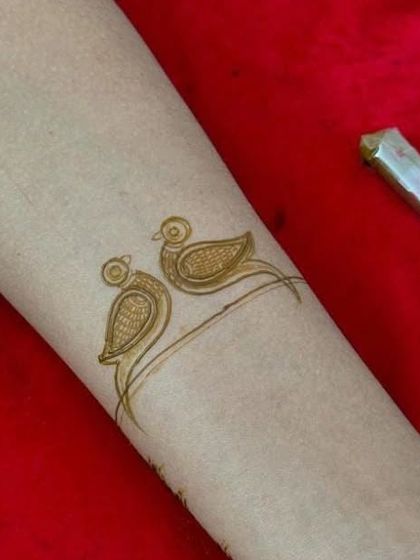 A very simple and cute bracelet design featuring two little birds. This is a great example of a quick, minimalist tattoo-style henna design.