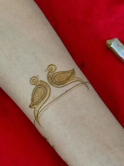 A very simple and cute bracelet design featuring two little birds. This is a great example of a quick, minimalist tattoo-style henna design.