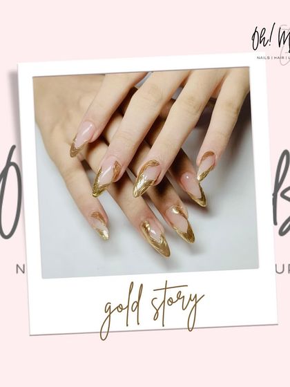 A full set of abstract gold chrome nails. The metallic gold is applied in a free-form pattern over a clear base, creating a unique and edgy look on long stiletto nails.