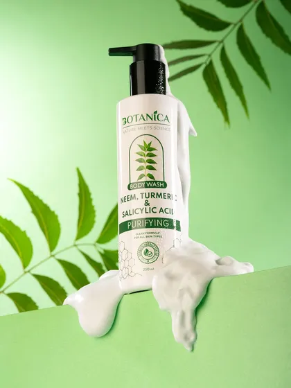A shot of a purifying body wash with a rich lather texture. The fresh green background and neem leaves visually reinforce the product's natural, purifying ingredients.