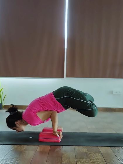 This is Padma Mayurasana, or Lotus in Peacock Pose. It's an advanced variation that combines the strength of Mayurasana with the hip flexibility of Padmasana (Lotus Pose).