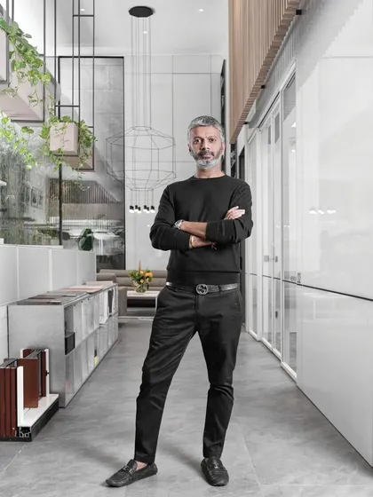 A portrait of me, Ar. Sumit Dhawan, in our studio corridor. The space is designed with a minimalist aesthetic, featuring clean lines and suspended planters, embodying our commitment to thoughtful and inspiring design.