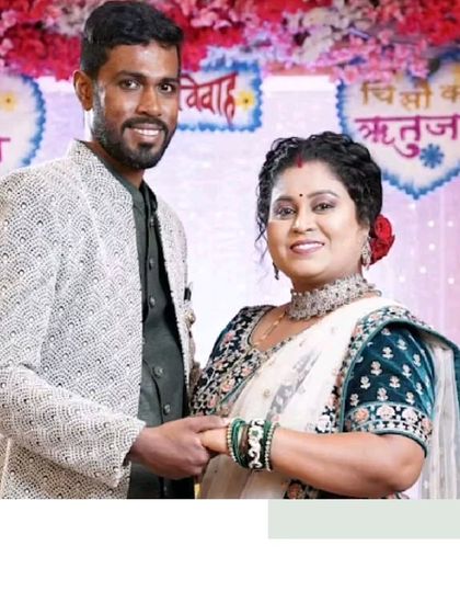 A beautiful moment from a wedding. The bride is wearing a traditional white and green saree, while the groom complements her in a modern textured Indo-Western jacket.