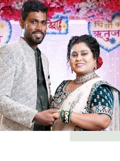 A beautiful moment from a wedding. The bride is wearing a traditional white and green saree, while the groom complements her in a modern textured Indo-Western jacket.