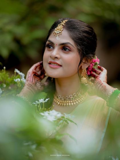 A beautiful close-up of the bride, her face framed by flowers, capturing her serene beauty on her wedding day at Guruvayur temple.