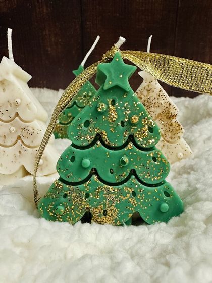 A green Christmas tree soy candle sparkling with gold glitter, a perfect addition to your holiday decor.