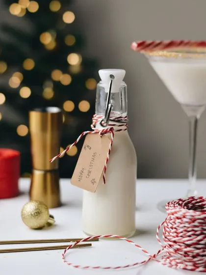 The best part about festivities is the drinks. This shot showcases a homemade vanilla Christmas drink, bottled and tagged as a gift, creating a festive and personal feel.