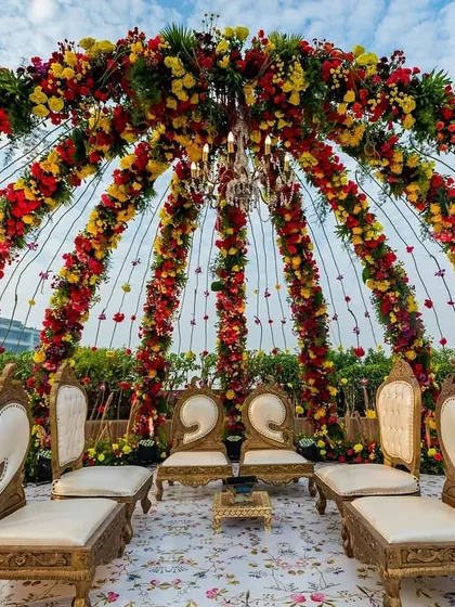 A rooftop wedding with a view of the city skyline calls for a spectacular mandap. We designed this floral dome structure, bursting with vibrant red and yellow flowers, to create a stunning focal point for a daytime ceremony at Jade Gardens.