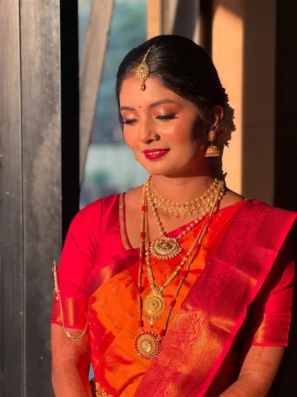My bride Raksha, looking stunning in the golden hour light, her red saree and gold jewellery glowing.