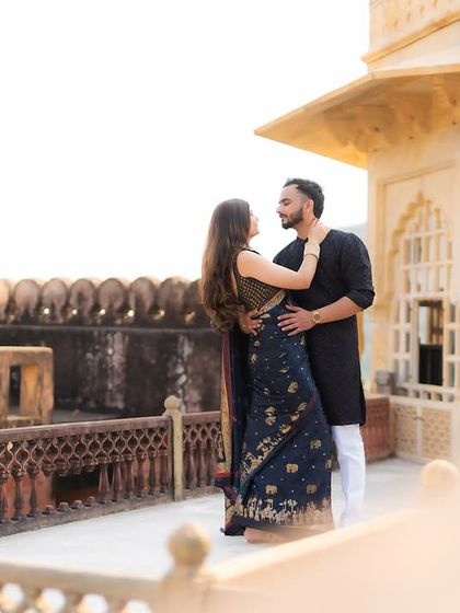 A romantic couple portrait on the terrace of a historic fort. The natural light and ancient architecture provide a beautiful setting for this intimate pre-wedding photography moment.