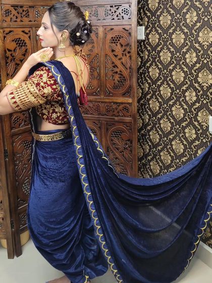 A side profile of the dhoti drape, highlighting the beautiful fall of the velvet and the intricate embroidery on the blouse.