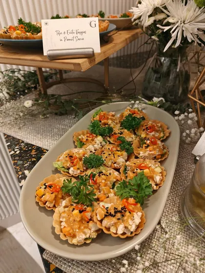 A platter of our Tofu & Exotic Veggies Tarts with a Peanut Sauce. These bite-sized tarts are a perfect fusion of flavors, ideal for any festive gathering.