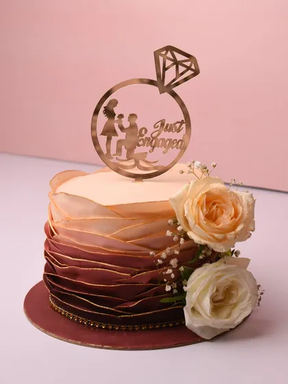 The delicate layers on this ombré engagement cake took forever, but the result was so worth it. The design features ruffled textures that fade from deep maroon to soft peach, finished with fresh roses and a "Just Engaged" topper.