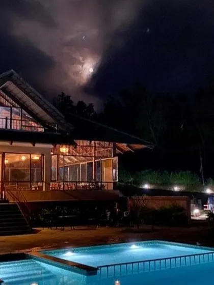A night view of the pool and main building at a Sakleshpur resort, perfect for a late-night swim under the stars.