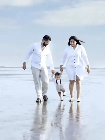 We capture beautiful family moments beyond the studio. This outdoor family photoshoot at a Mumbai beach showcases a candid, joyful walk, creating a perfect memory against a serene backdrop.