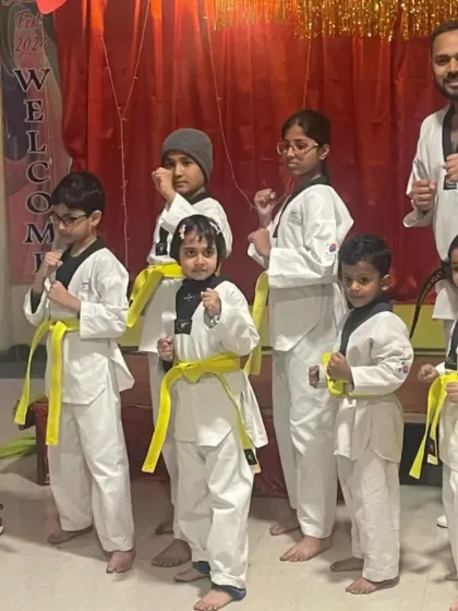 Our newly promoted yellow belts, standing in a ready stance with their coach. They are the future of Team Prahar.