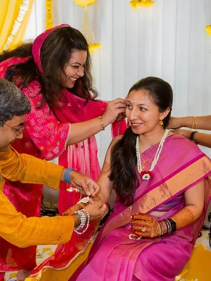 A lovely moment where family members come together to adorn the bride with floral jewellery during a pre-wedding ceremony.