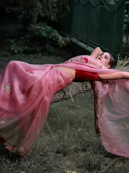 A dramatic pose that highlights the model's form and the sheer, flowing fabric of the saree.