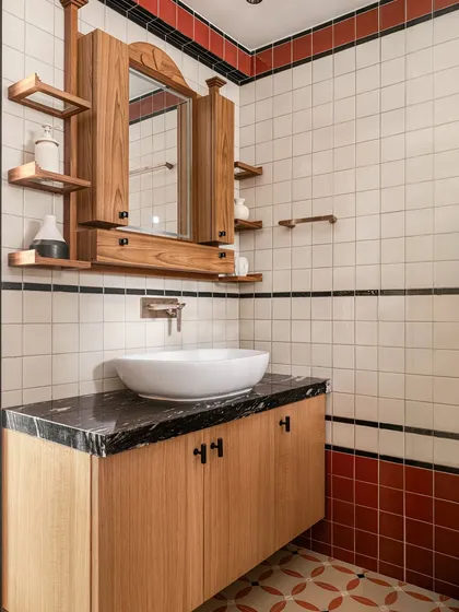 This bathroom from our Kolam Pop project uses a simple palette of white, terracotta, and black tiles to create a strong graphic rhythm. The custom teak vanity and mirror cabinet, with its asymmetrical shelves, adds a layer of handcrafted warmth.