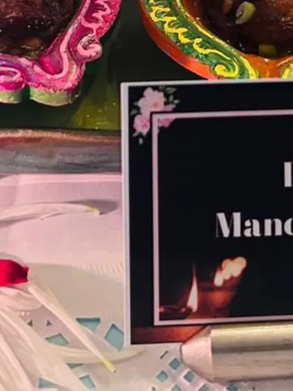 A close-up of the food label for "Dry Manchurian" next to the creative diya presentation. I ensure all my dishes are clearly labeled so guests know what they are enjoying.