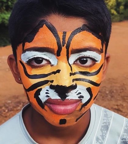 Face painting is a fun and creative activity at our camps. Here, a participant is transformed into a tiger.