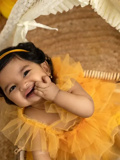 Celebrating the half-birthday milestone with a cheerful sunflower theme. This little one's shy smile and the warm, bohemian setup create a truly precious memory.