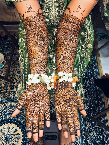 A beautiful Indian bridal design, adorned with fresh flowers. The intricate patterns cover the hands and arms completely for a classic look.