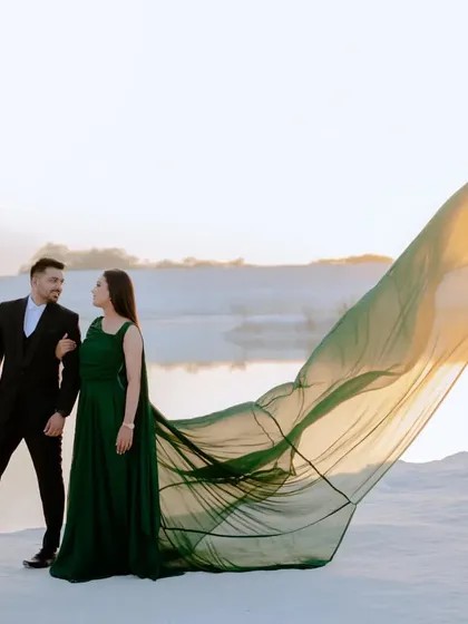 The setting sun catches the light through the bride's flowing green gown, creating a beautiful, ethereal glow. Sunset is my favorite time to shoot for this kind of magical effect.