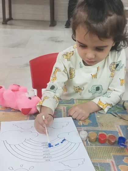An unedited moment from our session. This little girl is using a cotton bud for dot painting her rainbow, a technique that is great for developing a pincer grasp and fine motor control.