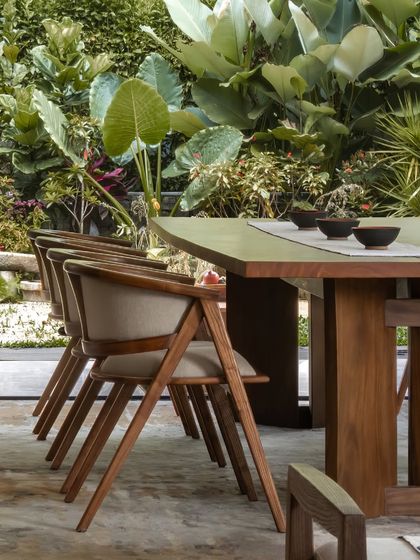 The dining area is framed by nature. We designed the space so the landscaped garden becomes a living, breathing part of the room.